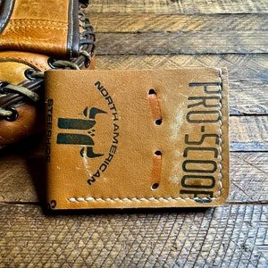 May include: A brown leather wallet with the text "PRO-SCOOP" and "NORTH AMERICAN STEERSHIDES" printed on it.
