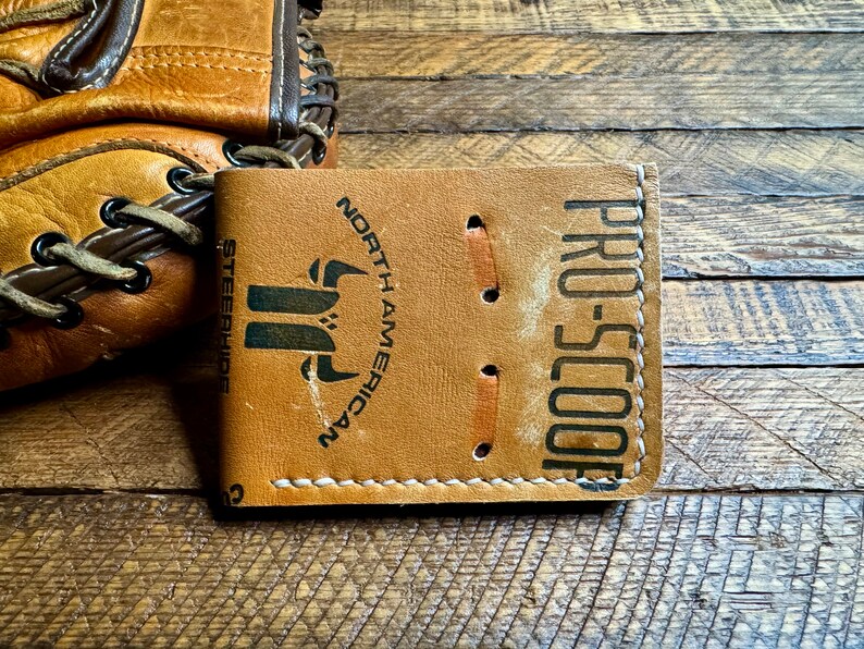 May include: A brown leather wallet with the text "PRO-SCOOP" and "NORTH AMERICAN STEERSHIDES" printed on it.