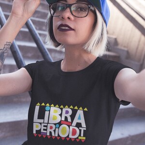 Puede incluir: Una camiseta negra con un gr&aacute;fico colorido que dice "LIBRA PERIODT" en un estilo retro.