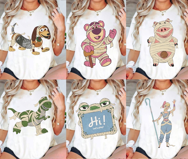 May include: A white t-shirt featuring a graphic print of a character wrapped in bandages like a mummy. The design includes a dog, a bear, a pig, a dinosaur, a blue sign with the text Hi! Let's play!, or a shepherd character with a staff.