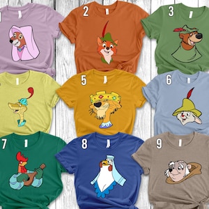 Pode incluir: Uma coleção de nove camisetas de manga curta em várias cores, cada uma apresentando um gráfico de personagem de desenho animado diferente do filme Robin Hood, numeradas de um a nove, incluindo Maid Marian, Robin Hood, Little John, Sir Hiss, Prince John, Allan-a-Dale, Friar Tuck e outros.