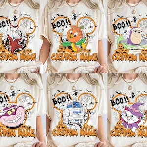 May include: A cream-colored t-shirt featuring six distinct Halloween-themed graphic designs. Each design includes a character, a spider web, bats, pumpkins, the text BOO!!, and a space for a custom name in orange, dripping, spooky-style lettering.