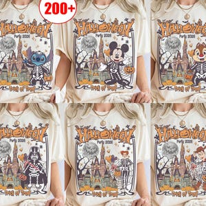 May include: A cream-colored t-shirt featuring a graphic print of a Halloween party scene with a castle, a full moon, pumpkins, and various characters in skeleton costumes, including text that reads Halloween Party 2026 and Trick or Treat.