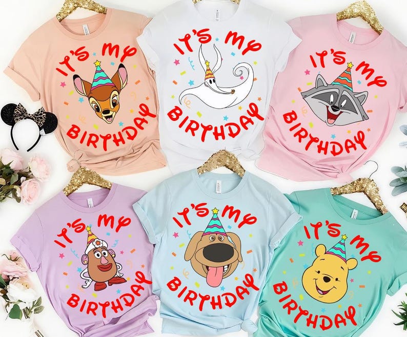 May include: Six short-sleeve t-shirts in peach, white, pink, lavender, light blue, and mint green. Each shirt features a cartoon character wearing a colorful party hat, surrounded by the red text "IT'S MY BIRTHDAY" and small confetti shapes.