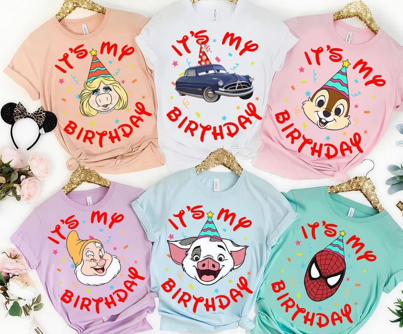 May include: Six short-sleeved t-shirts in peach, white, pink, lavender, light blue, and teal. Each shirt features the red text "IT'S MY BIRTHDAY" surrounding a cartoon character wearing a colorful party hat, including Miss Piggy, a car, Chip, Dopey, Pua, and Spider-Man.