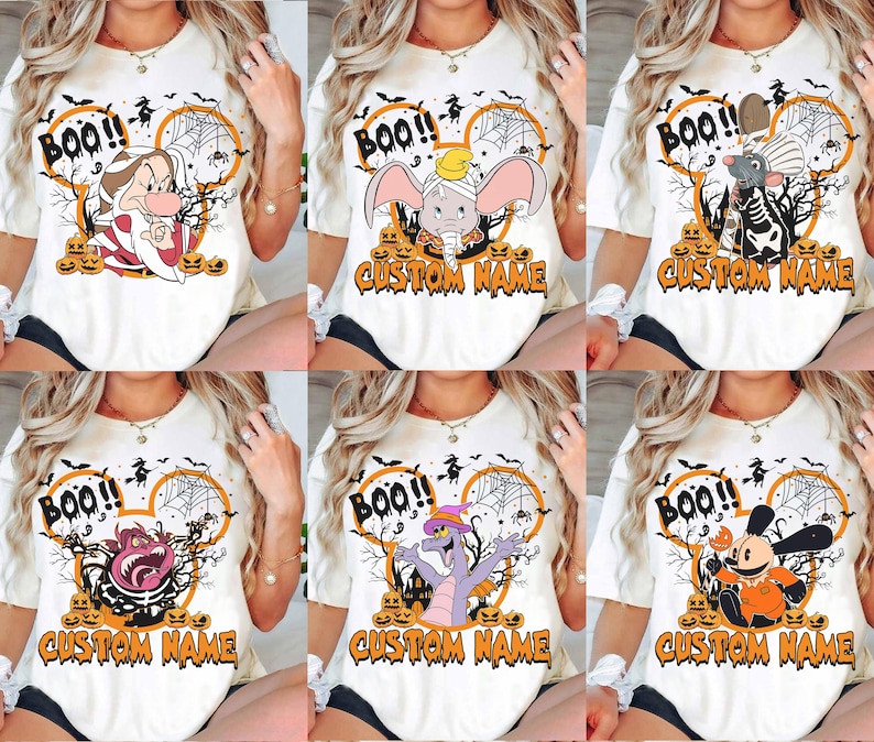 May include: A white t-shirt featuring a Halloween-themed graphic with a mouse-ear silhouette, spider webs, pumpkins, and the text "BOO!!" and "CUSTOM NAME". The design includes various cartoon characters like Dumbo, Remy, and others.