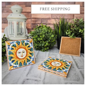May include: Four ceramic coasters with a blue, yellow, and green design featuring a smiling sun face. The coasters are on a white surface with a brick background. FREE SHIPPING text is visible at the top of the image.