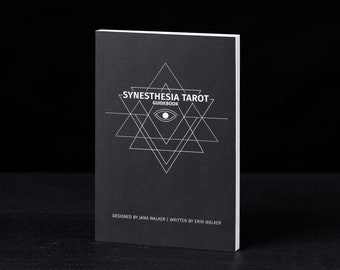 May include: Black guidebook with a white geometric design and the text "Synesthesia Tarot Guidebook" on the front cover. The text "Designed by Jana Walker | Written by Erin Walker" is at the bottom of the cover.