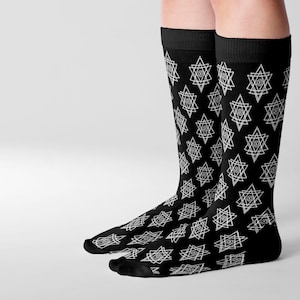 May include: A pair of black knee-high socks with a white geometric pattern of repeating star shapes.