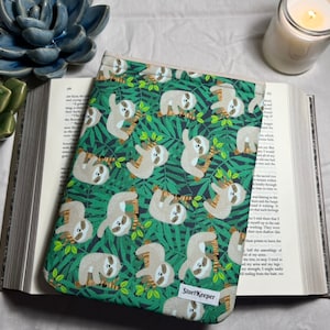 May include: A green and brown book cover with a sloth pattern. The cover has the text "StoryKeeper" on the bottom right corner.