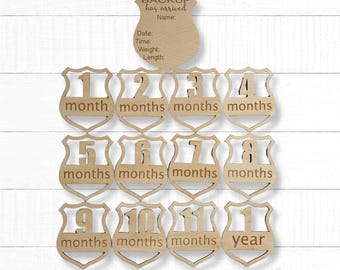 May include: Wooden baby milestone photo props. Includes a shield-shaped sign with the text "BACKUP has arrived" and space for baby's details. Also includes 12 month markers, from 1 month to 1 year.