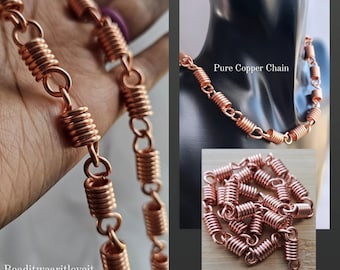 May include: A copper chain necklace with coiled links. The chain is displayed on a mannequin and on a hand. The text "Pure Copper Chain" is visible on the image.