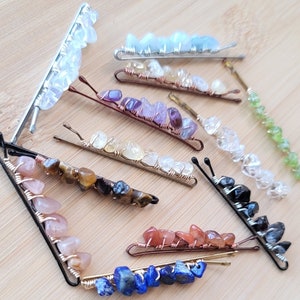 May include: Assortment of handmade hair clips featuring various semi-precious stones, including amethyst, aquamarine, tiger's eye, carnelian, and lapis lazuli. Each clip is made with wire wrapped stones and has a silver or gold tone finish.
