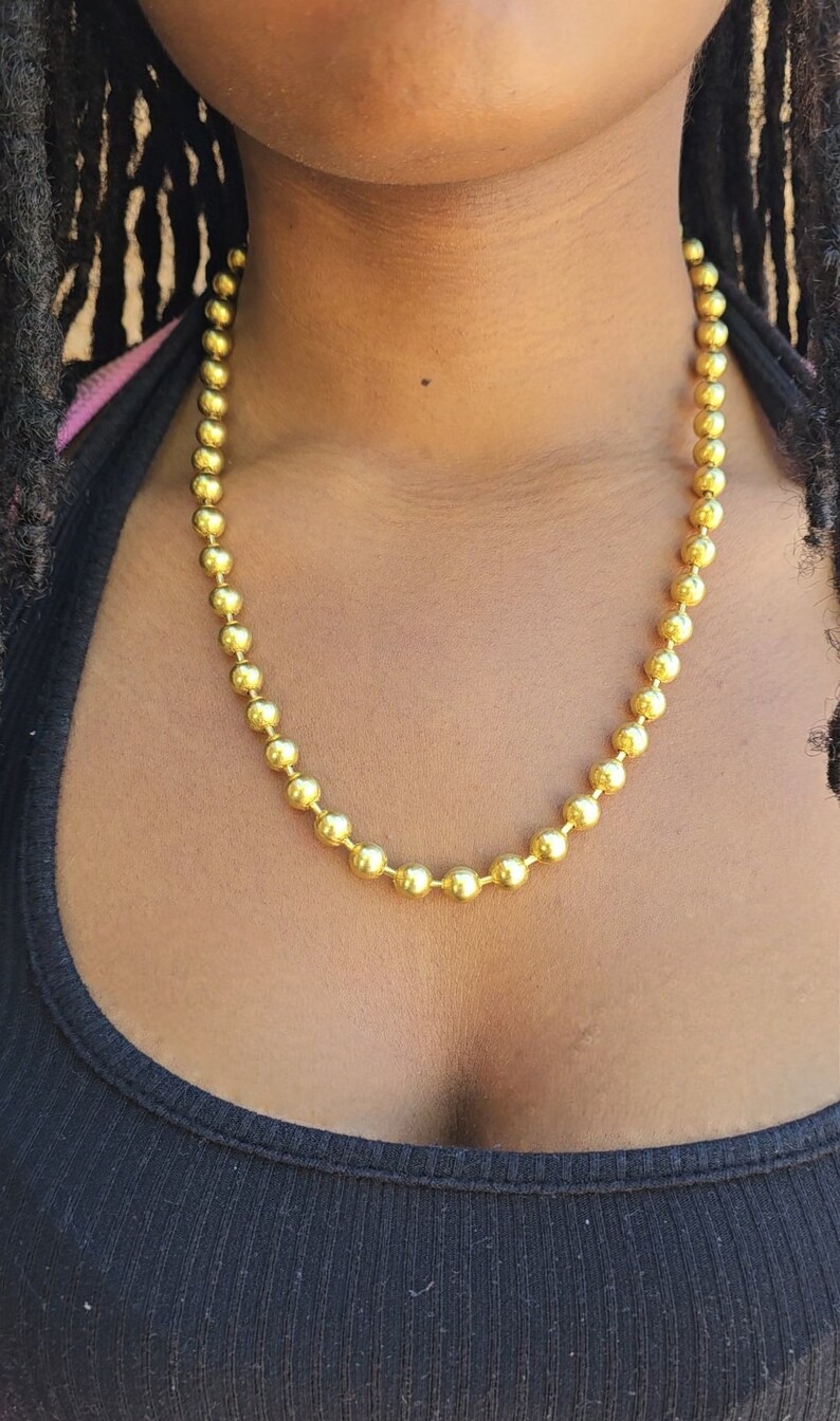 Op de afbeelding: Een gouden ketting met ronde kralen.