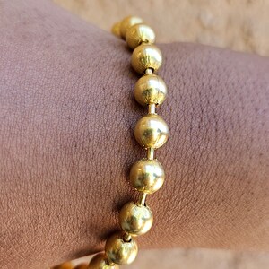 Op de afbeelding: Een gouden armband met ronde kralen.