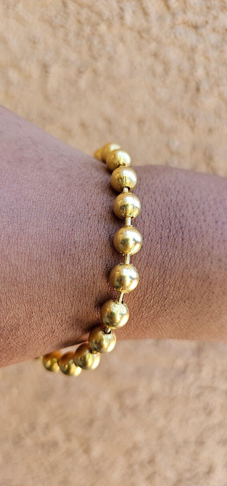 Op de afbeelding: Een gouden armband met ronde kralen.