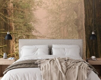 May include: A white bed with a beige blanket and two white pillows. The bed is in front of a wall with a photo mural of a misty forest.