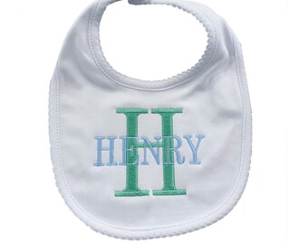 May include: White baby bib with a scalloped edge and the name "HENRY" embroidered in blue and green.