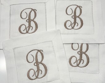 May include: Four white linen cocktail napkins with a brown embroidered letter "B" in a cursive font.
