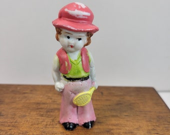 Cute tennis player bisque Penny doll with a racquet, dressed in pink and green with a hat, vintage