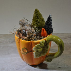 Viñeta en miniatura de otoño, ardilla vintage en una taza de calabaza, árboles hechos con cepillos para botellas, musgo, decoración de otoño