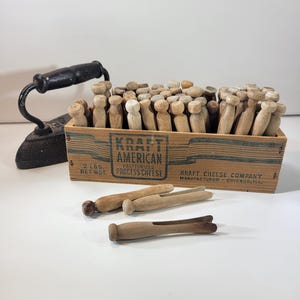 Vintage wooden clothespins in an old Kraft American cheese box, laundry room decor, assorted clothespins