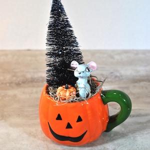 Pequeño ratón en una viñeta en miniatura de otoño, calabaza y árbol de cepillo de botella negro en una taza de calabaza, decoración de otoño