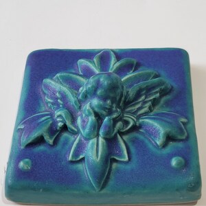 Artisan Tyge Tile featuring a cherub and floral design, ceramic, made in Michigan, USA