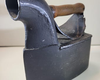Antique Victorian cast iron coal-fired clothes iron featuring a chimney and wooden handle