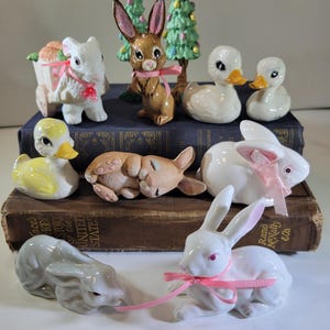 Selección de pequeñas figuras de Pascua, conejos, patos, árboles y materiales para manualidades.