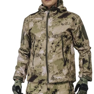 Puede incluir: Una chaqueta de camuflaje con cierre de cremallera y capucha. La chaqueta tiene varios bolsillos y un parche en la manga izquierda.