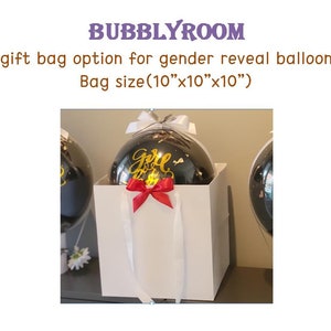 Puede incluir: Una bolsa de regalo blanca con asas blancas y un lazo rojo. Un globo negro con letras doradas que dicen "Girl" est&aacute; dentro de la bolsa. La bolsa mide 25 cm por 25 cm por 25 cm.