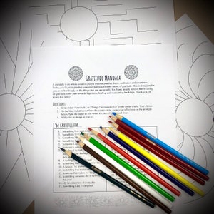 May include: A "Gratitude Mandala" coloring page with text and prompts, alongside a set of colored pencils. The page features a circular design with the words "Gratitude Mandala" at the top. The prompts encourage reflection on gratitude.