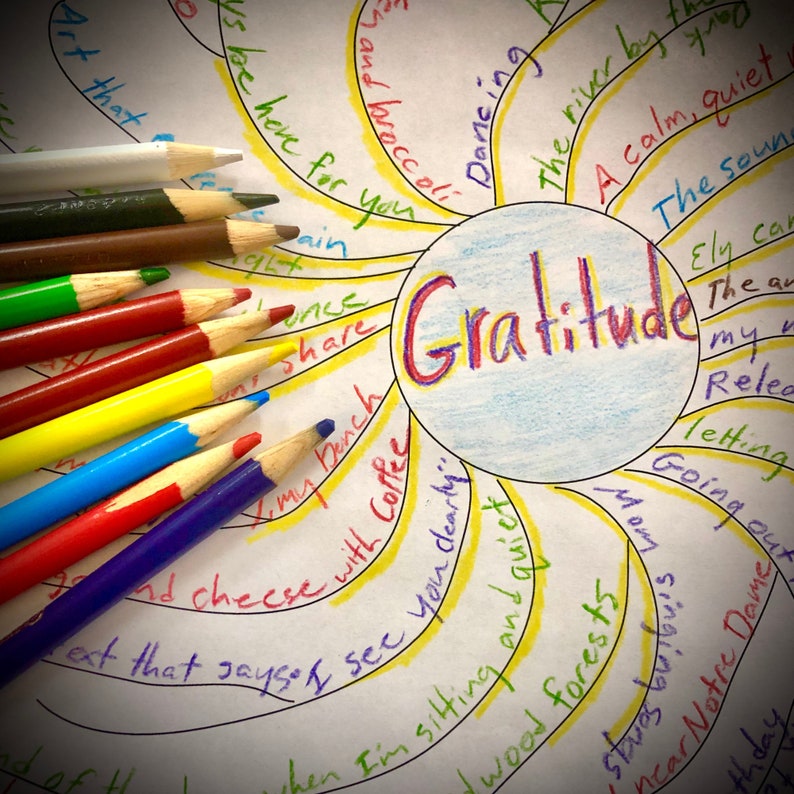 May include: A colorful illustration with the word "Gratitude" in the center, surrounded by handwritten notes and colorful pencils. The pencils are arranged along the left side, with various colors like red, yellow, and blue. The theme is centered around mindfulness and reflection.