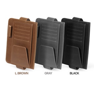 May include: Three car visor organizers in different colors: light brown, gray, and black. Each organizer has multiple card slots, a pocket, and a strap.