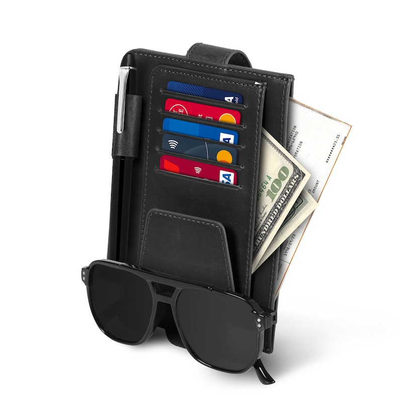 May include: A black leather wallet with a pen holder, credit card slots, and a cash compartment. The wallet is closed and has a pair of black sunglasses on top of it.