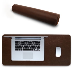 May include: A brown leather desk mat with a laptop and a white mouse on top. The mat is rolled up in the top left corner of the image. The text "LOMOKO" is visible in the bottom right corner of the mat.