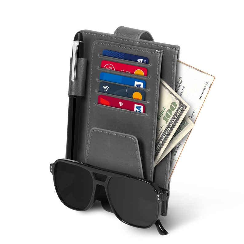 May include: A gray leather wallet with a pen, credit cards, and a $100 bill inside. The wallet also has a black sunglasses case attached to it.