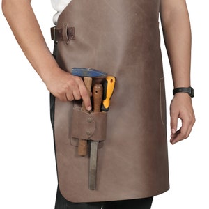 May include: A brown leather tool apron with a hammer, screwdriver, and file in a pocket.