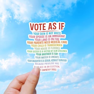 Könnte beinhalten: Ein Aufkleber mit dem Text "VOTE AS IF" in Rot, gefolgt von einer Liste von Aussagen in verschiedenen Farben. Der Aufkleber wird vor einem blauen Himmel mit weißen Wolken gehalten.