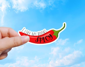 May include: A red chili pepper sticker with a green stem featuring the black text I LIKE MY BOOKS SPICY. The sticker has a white border and is shaped like a curved chili pepper, with the word SPICY written in a larger, cursive script font.