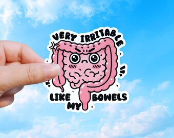 May include: A pink sticker with a cartoon illustration of intestines with an angry face. The text on the sticker reads "VERY IRRITABLE LIKE MY BOWELS" in black, bold letters. The sticker is held against a blue sky background.