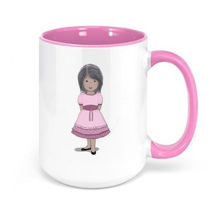 Może przedstawiać: Biały kubek ceramiczny z różowym rantem i uchwytem. Kubek przedstawia kreskówkową ilustrację dziewczynki w różowej sukience z białym kołnierzykiem i różową kokardką.