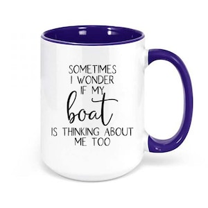 May include: White ceramic coffee mug with a purple rim and handle. The mug has a quote that reads "Sometimes I wonder if my boat is thinking about me too."