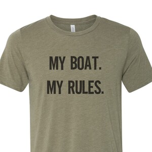 Puede incluir: Una camiseta verde con el texto "MY BOAT. MY RULES." impreso en negro.