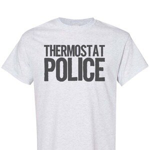 May include: A light grey t-shirt with the text "THERMOSTAT POLICE" printed in black.