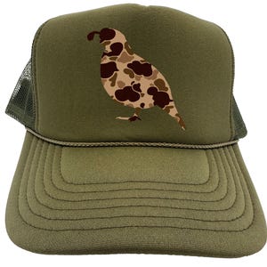 May include: A green trucker hat with a camouflage quail design. The hat has a mesh back and a curved brim.
