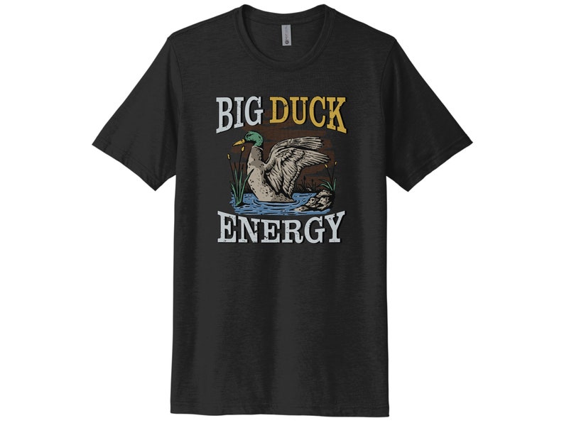 May include: A black t-shirt with a vintage-style illustration of a duck in a pond. The text "BIG DUCK ENERGY" is printed in yellow and white on the shirt.