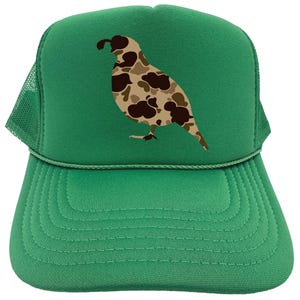 May include: A green trucker hat with a camouflage quail design. The hat has a mesh back and a green front.
