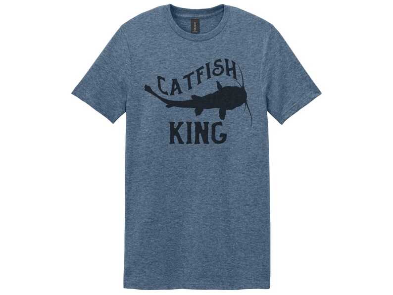 May include: A blue heather t-shirt with a black silhouette of a catfish and the text "Catfish King".